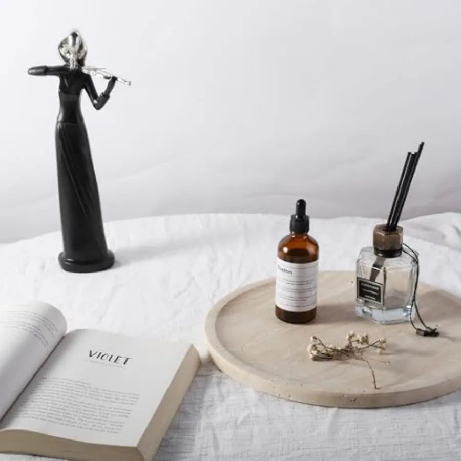 Round travertine tray styled with a reed diffuser and book