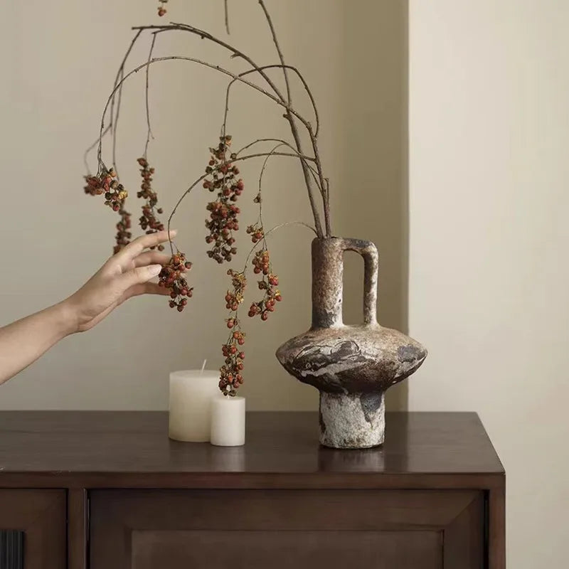 Rustic wabi-sabi stoneware vase styled with dried branches on a credenza