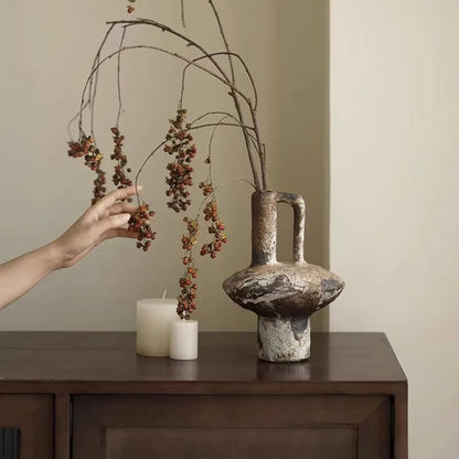 Rustic wabi-sabi stoneware vase styled with dried branches on a credenza